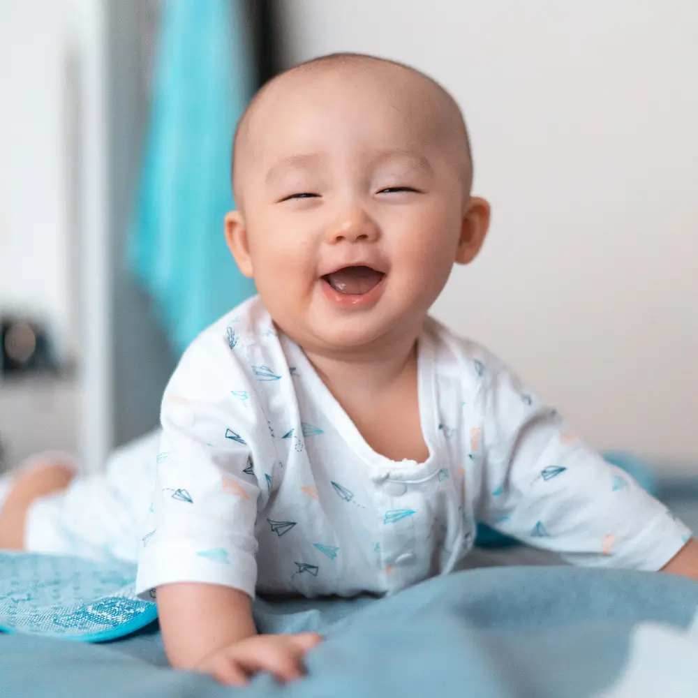 asian baby smiling happy represent why crawling is important for healthy infant brain development