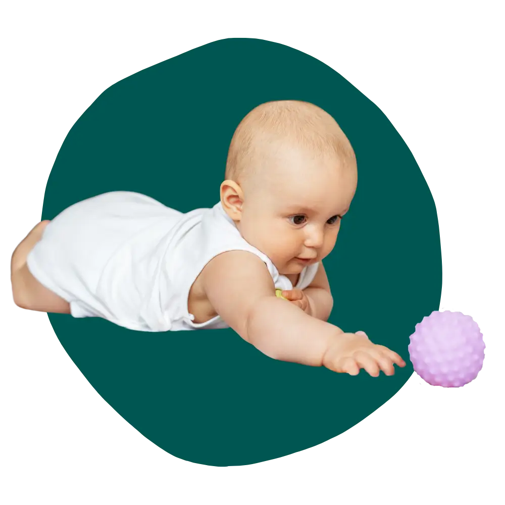infant baby reaching hand out toward developental toy ball
