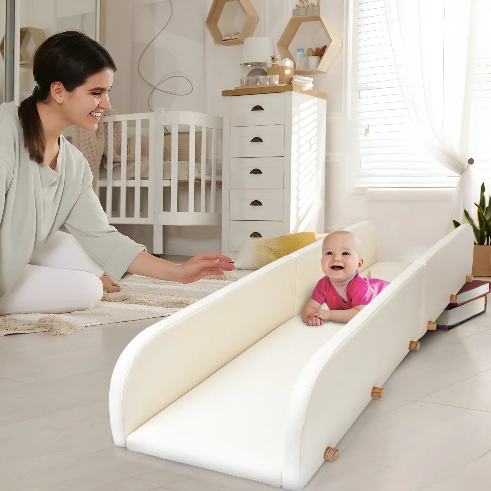 mother holds out a reassuring hand as her baby learns to use the crawlaroo infant crawling track and tummy time toy during tummy time to learn to crawl